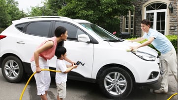 family washing the car in the driveway