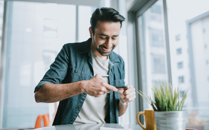 Man using his phone to do his banking with Orange County's Credit Union