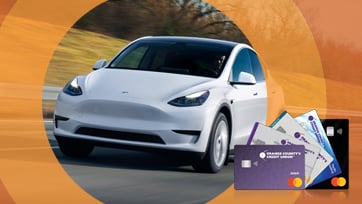 New Tesla vehicle driving on road with Orange County's Credit Union Debit Mastercard and Platinum Credit Card Offering overlaid on top and disclaimer text Vehicle image is courtesy of Tesla Motors, Inc.